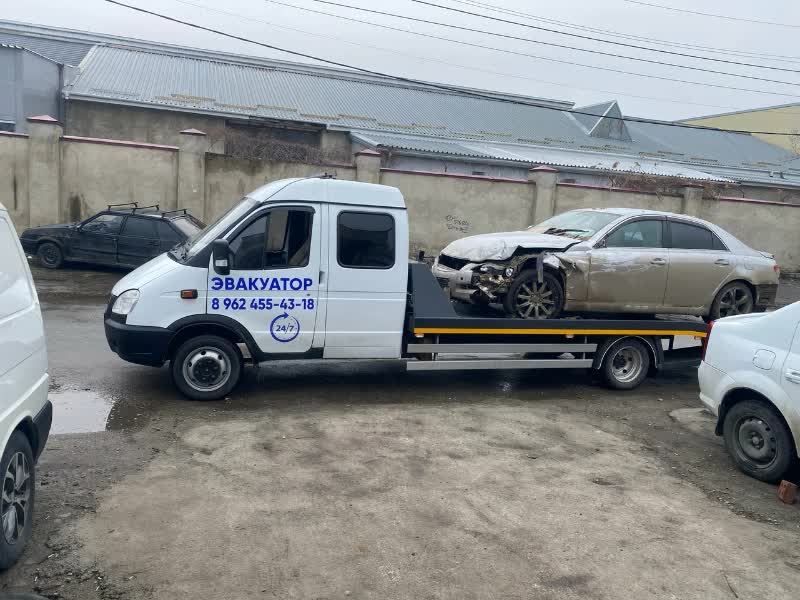 Эвакуатор вытягивает автомобиль из кювета лебедкой